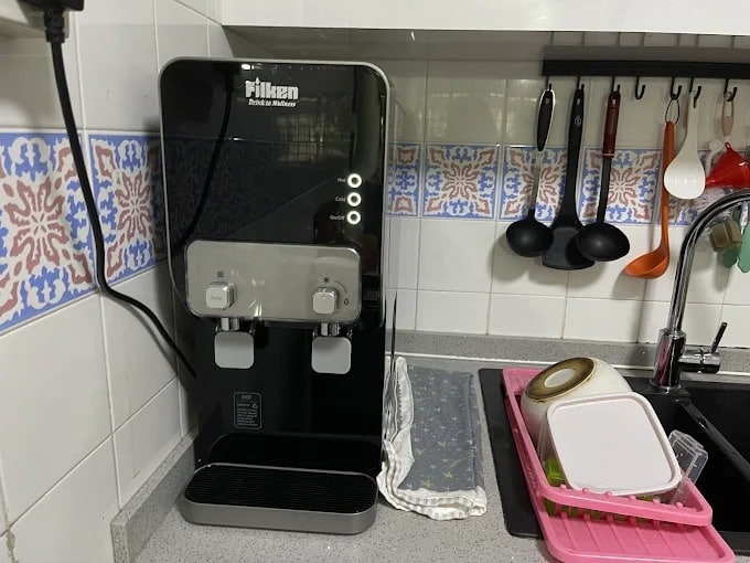 Black indoor water dispenser installed in kitchen